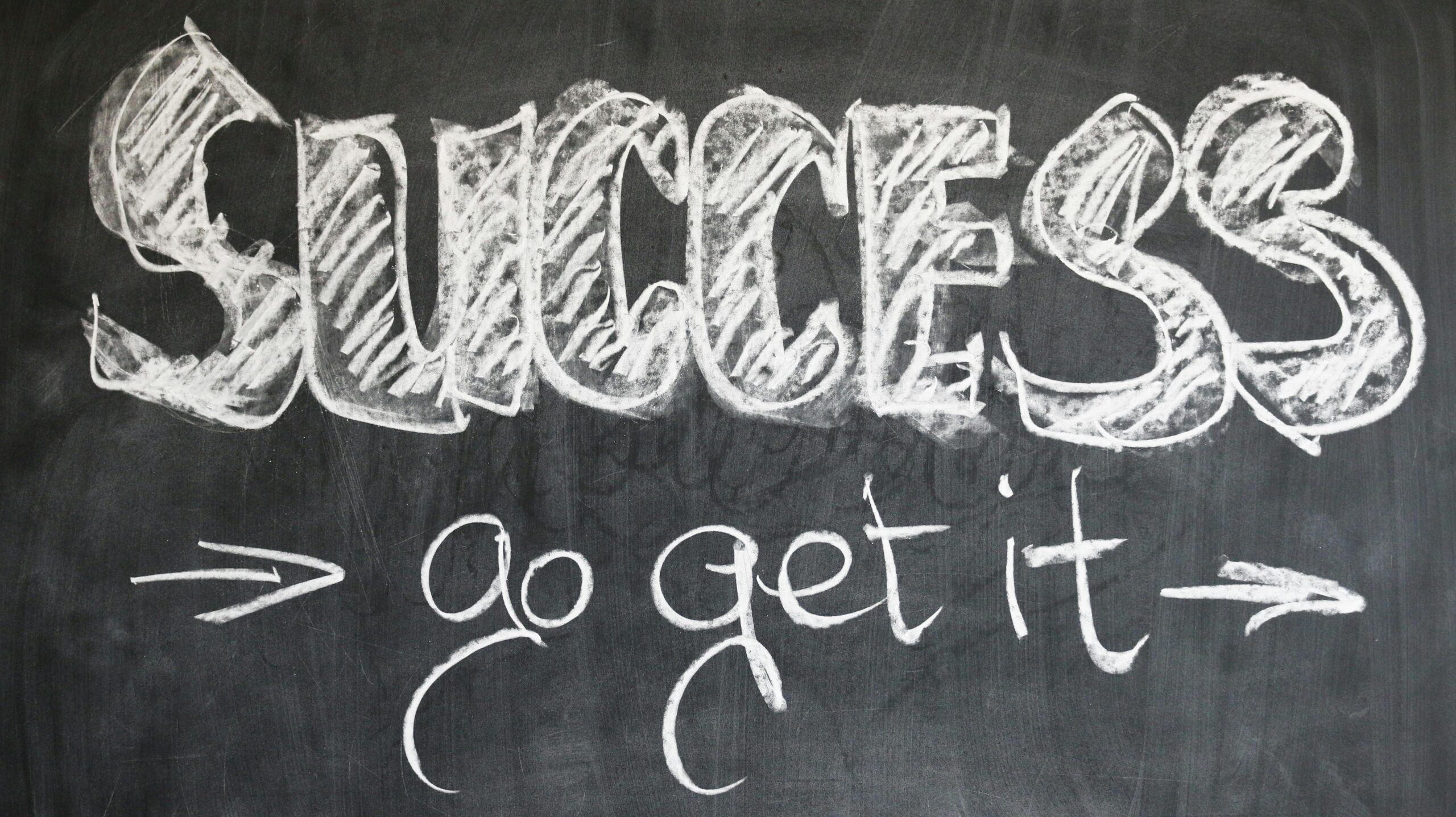 Success go get it written on a chalkboard with arrows pointing right.